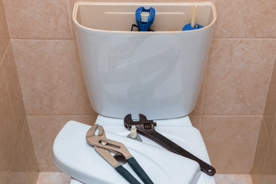 toilet repair with plumbing tools