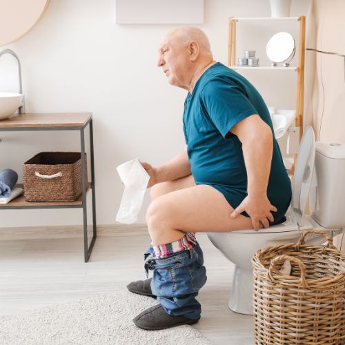 senior aged man sitting on a toilet